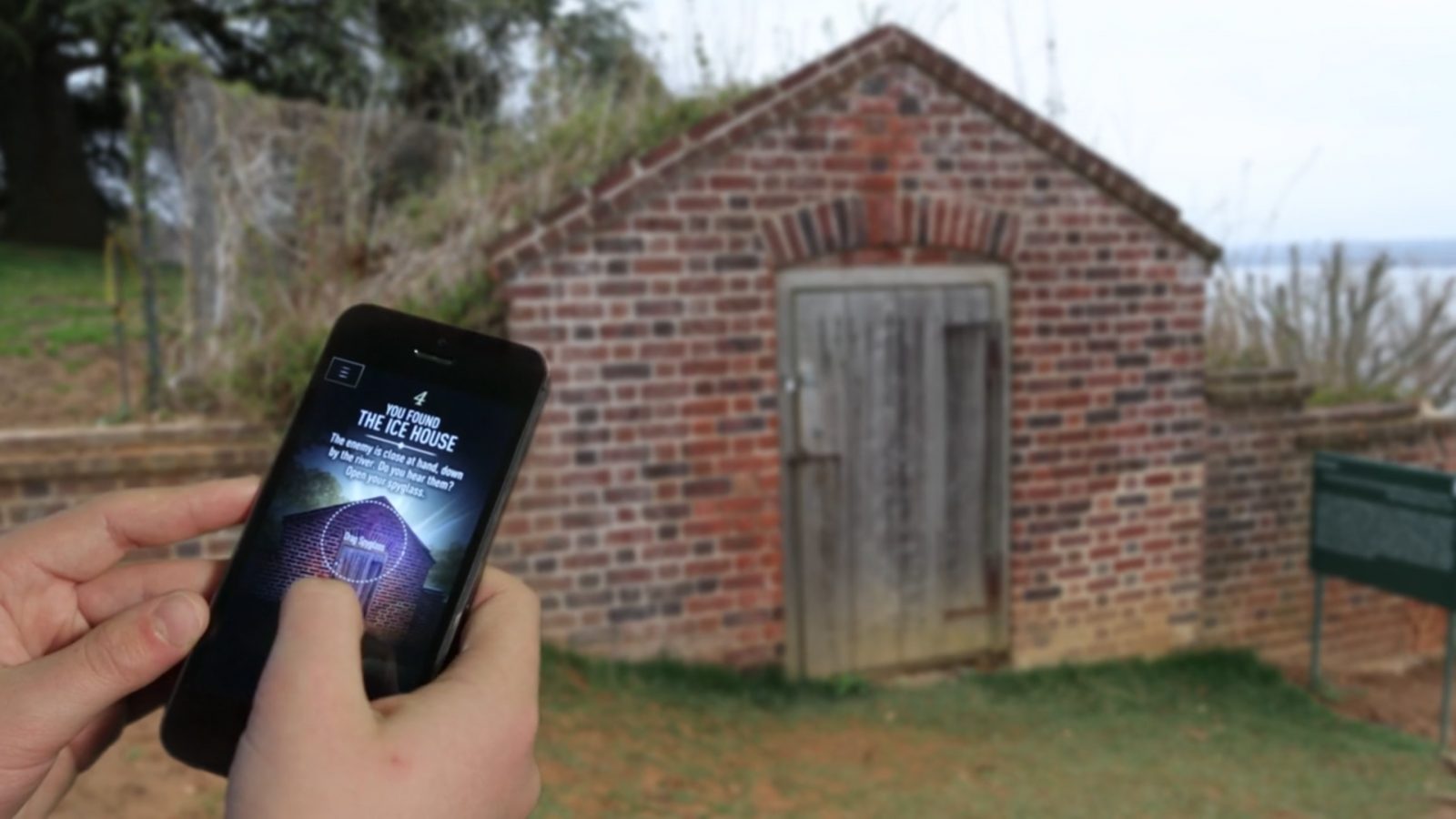 A visitor at the brick ice house consulting a spy challenge on their phone