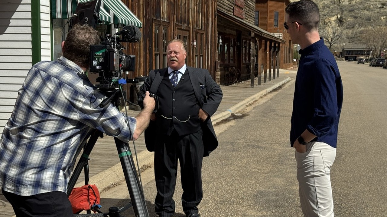 A camera operator filming a period-costumed interpreter on Medora's historic main street