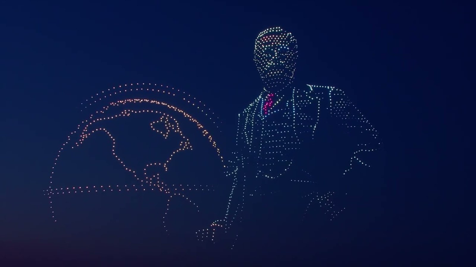 Theodore Roosevelt rendered in illuminated drones beside a globe, in the night sky over the North Dakota Badlands