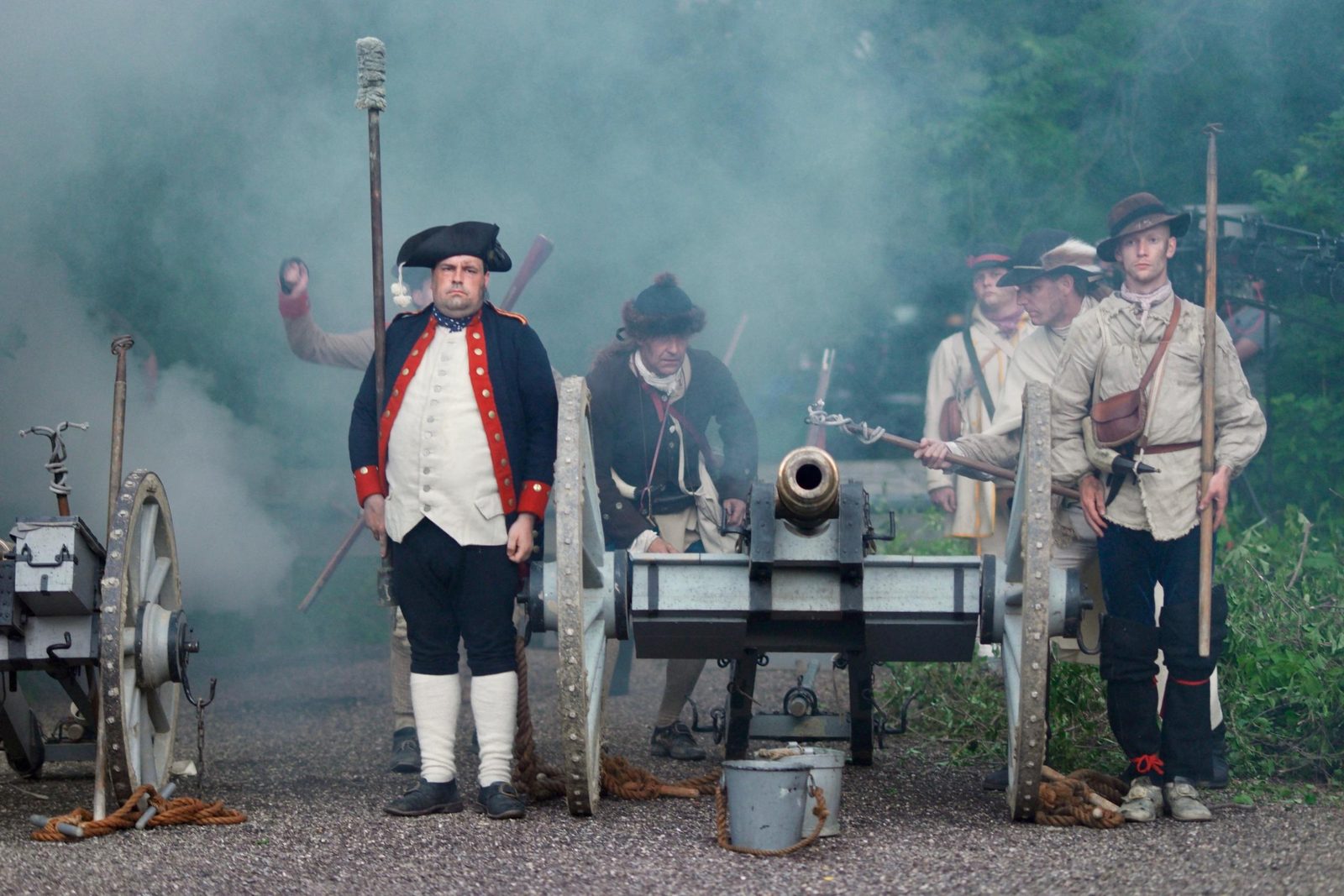 Artillery crew of reenactors with cannon smoke