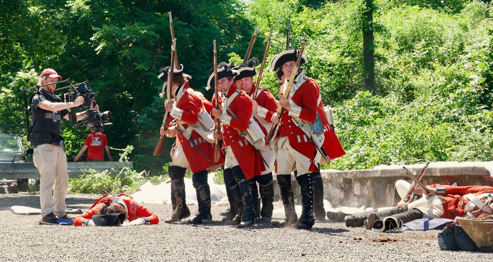 Camera operator on location with British reenactors in red coats
